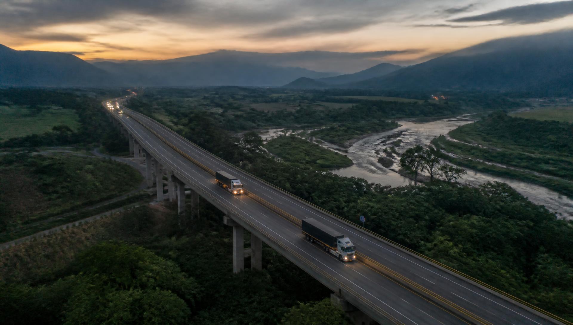 Corredor vial atravesando un valle colombiano al atardecer