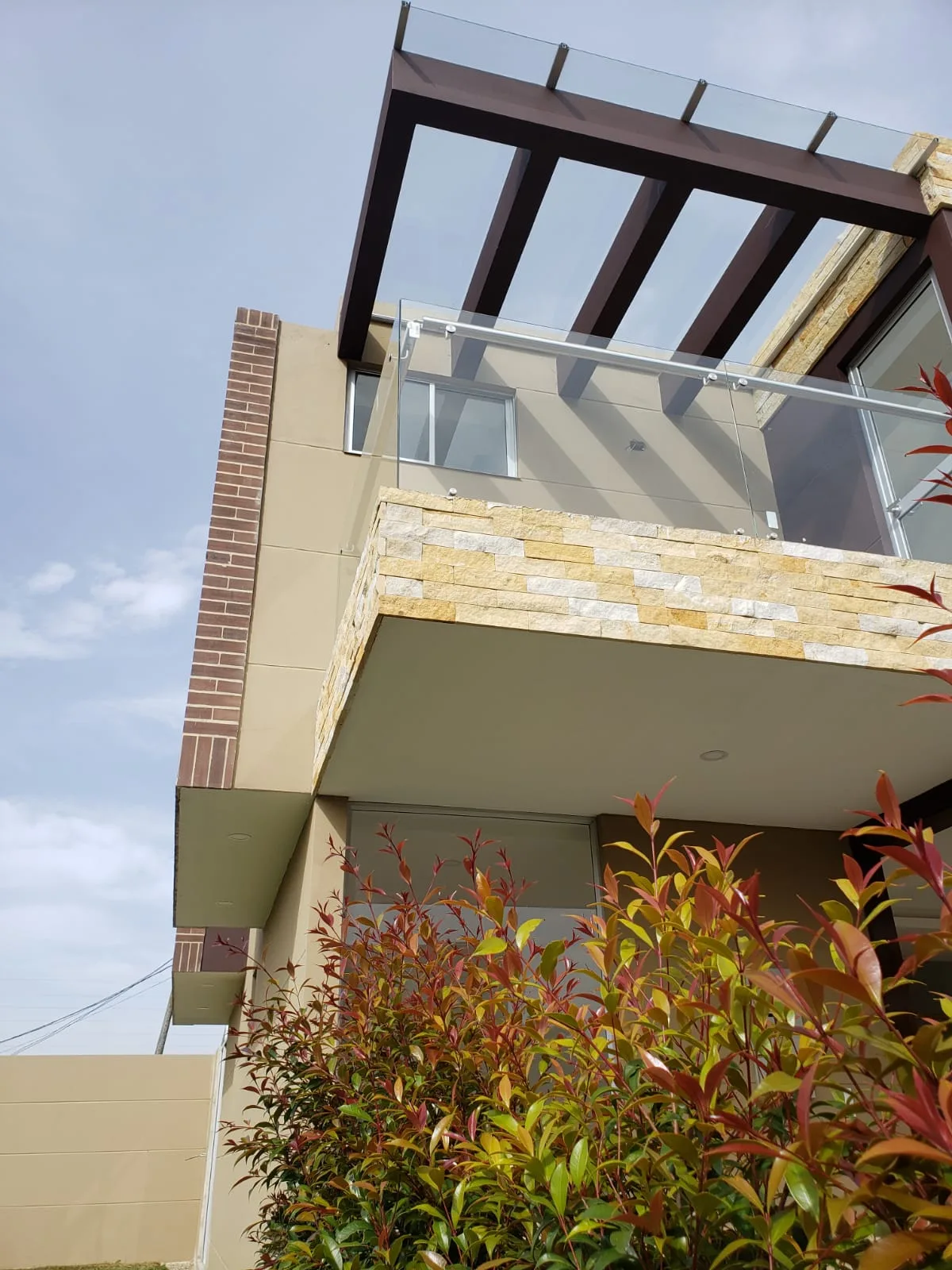 Foto real de pasillo de acceso a una casa Bosco Reservado con baldosas en concreto, gravilla y jardinería ornamental