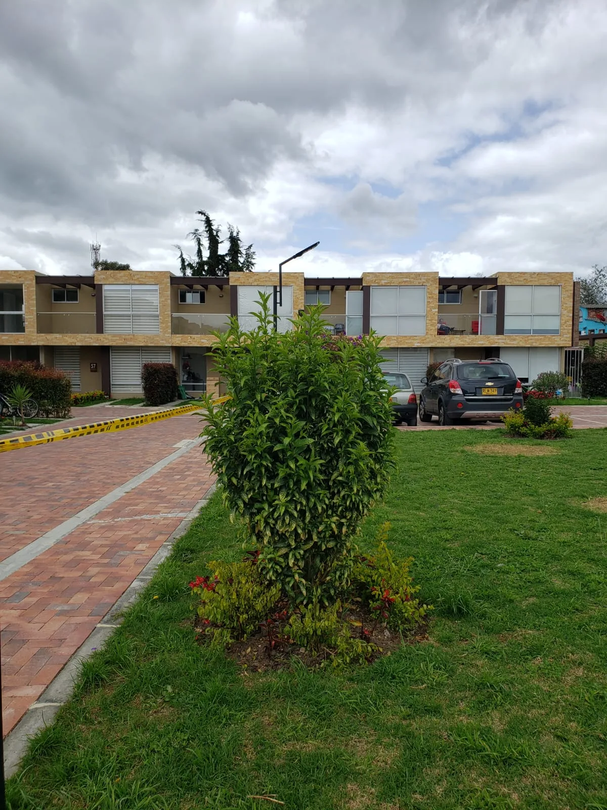 Foto real de zonas verdes interiores de Bosco Reservado con jardines, andenes en gres y casas terminadas