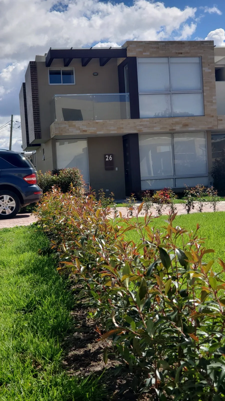 Foto real del acceso de la casa 26 de Bosco Reservado con jardín ornamental y antejardín
