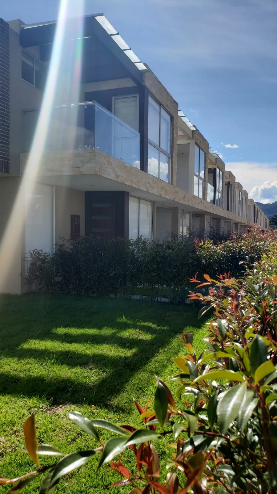 Foto real lateral del conjunto Bosco Reservado con los cerros de Chía al fondo y jardines en primer plano